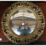 A 20th century convex wall mirror, within a gilt effect pierced scrolling foliate frame, 46cmD