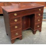 A small Edwardian kneehole desk/dressing table, marquetry and crossbanded top, surrounded by several