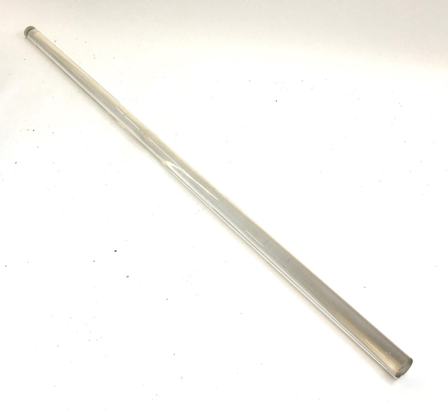 A long glass rod, possibly a ledger magnifier or desk rule