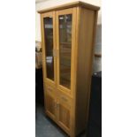 A contemporary glazed oak cabinet, with single drawer above two cupboard doors, 88x38x196.5cm