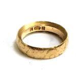 An 18ct gold wedding band with chamfered edges, 7.4g, size M