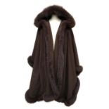 A Turkis Tukku fur and leather trimmed wool cape with hood, made in Finland