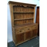 A 19th century pine dresser, the top with two shelves on a base of three drawers over three cupboard