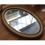 An oval wall mirror with bevelled glass, 52cmH