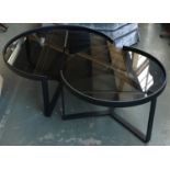 Two interlocking metal and smoked glass circular coffee tables, 89cmD and 70cmD