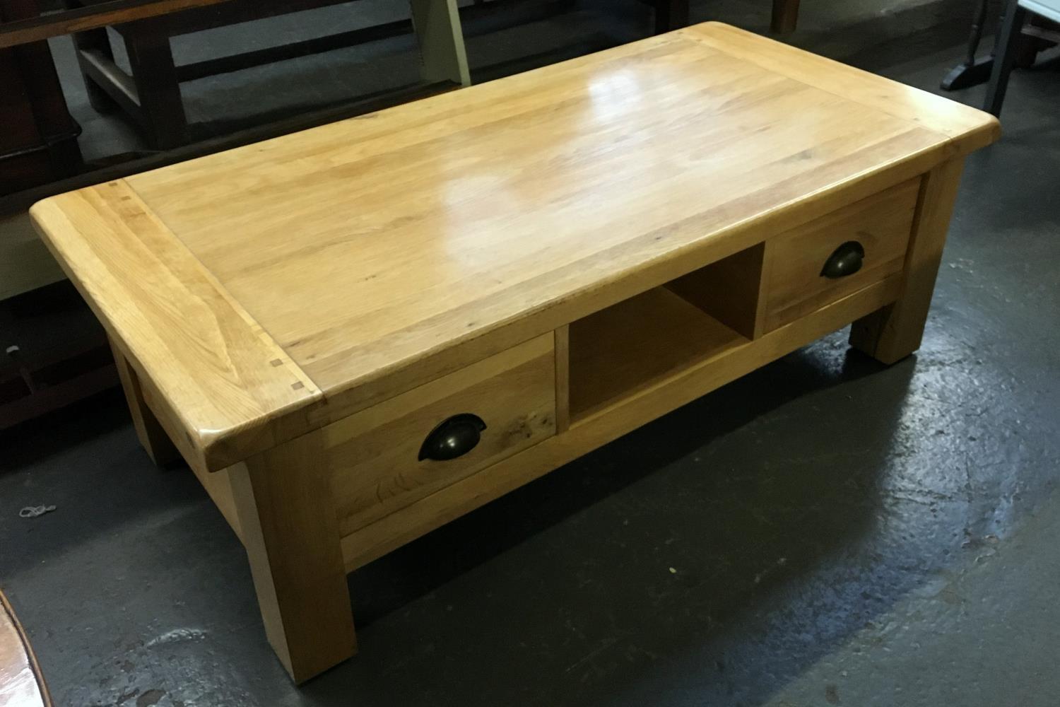 A contemporary blond oak solid coffee table, having two drawers, 120x59x41cmH