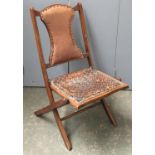 A folding campaign chair with leather upholstery, together with a rocking chair