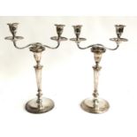 A pair of probably Indian silver plate two arm candlesticks, on faceted tapering columns and