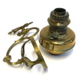 A brass wall mounted oil lamp with hinged bracket