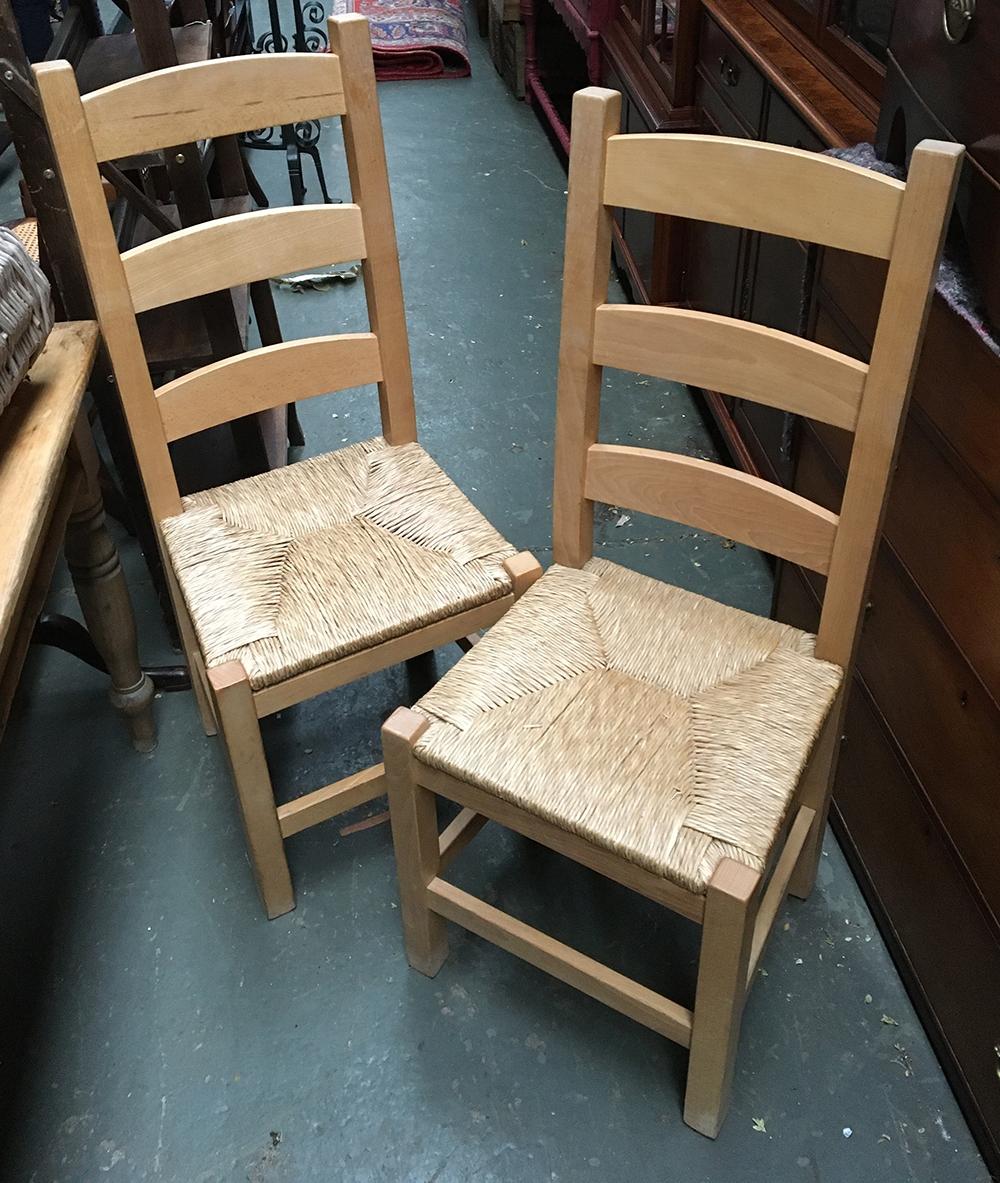 A pair of modern kitchen chairs with rush seats