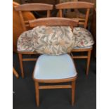 A set of three mid-century beech kitchen chairs with vinyl seats and cushions