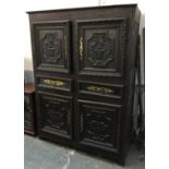 A large continental oak cupboard having four doors separated by two drawers, each door panel