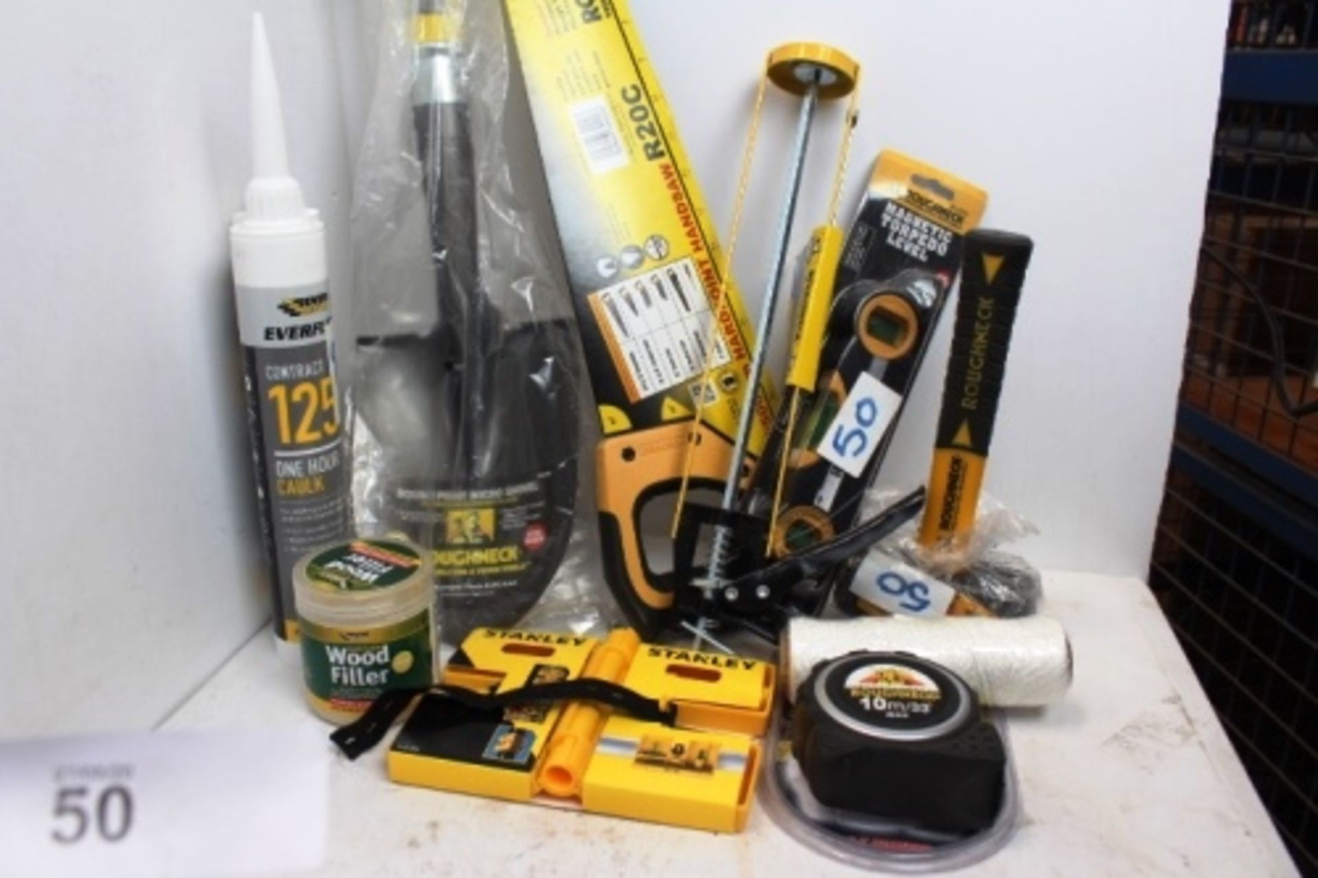 An assortment of tools including Roughneck 1.8kg sledgehammer, handsaw, caulking gun, spirit