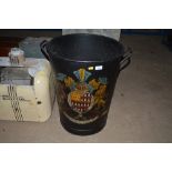 A twin handled painted metal bin decorated with a
