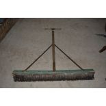A large wooden yard broom