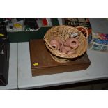 A wicker basket containing various doll parts and