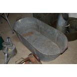 An oval galvanised twin handled bath