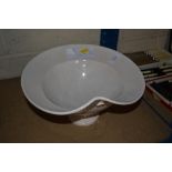 A white glazed ceramic pedestal bowl