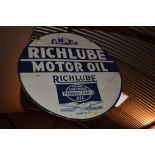 A circular enamel sign for "Richlube Motor Oil"