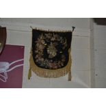 A Victorian embroidered silk panel with tassels an