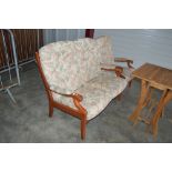 A wooden framed two seater settee and matching arm