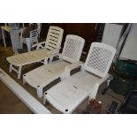 Three white plastic garden loungers