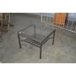 A metal and glass topped garden table