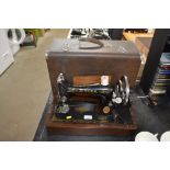 A Singer hand sewing machine in fitted case