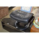 A black leather upholstered foot stool