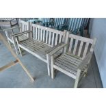 A teak garden bench; two matching armchairs
