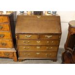 An Antique oak bureau, the fall front opening to reveal an interior arrangement of drawers, two