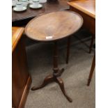 A Georgian mahogany occasional table, the oval dished top raised on turned column and tripod base,
