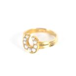 A 15 carat gold horseshoe and seed pearl set ring