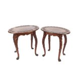 A near pair of carved oak occasional tables, having oval stylised leaf border tops, raised on