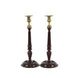 A pair of 19th Century mahogany and brass candlesticks, raised on fluted baluster columns and