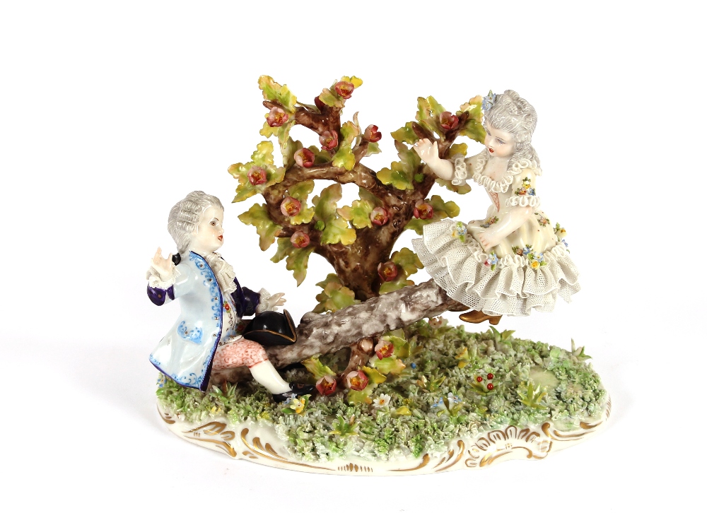 A Continental porcelain figure group, depicting children playing on a see-saw with floral