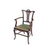 An Edwardian mahogany saloon elbow chair, having carved cresting rail and pierced splat back, dralon