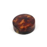 A 19th Century tortoiseshell patch box, of circular form with mirror inset lid, 5cm dia.