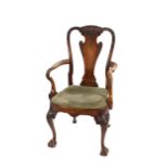 A walnut elbow chair, in the George II style, having carved foliate decoration, vase splat back