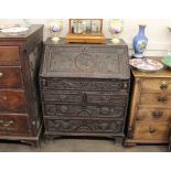 An Antique carved oak bureau, the fall front opening to reveal an interior arrangement of drawers