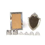 Three pairs of ornate silver menu holders; an Edwardian silver shield shaped mirror with garland and