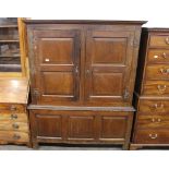An Antique oak press cupboard, enclosed by a pair of fielded panelled doors above three panel