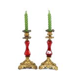 A pair of 19th Century ruby glass and gilt metal baluster candlesticks, with raised foliate