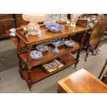 A Victorian mahogany three tier buffet, raised on baluster turned supports, terminating in brass