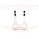 A pair of cut glass and silver mounted decanters, having raised foliate decoration, 33cm