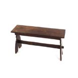 An Antique oak bench, having shaped end supports united by a stretcher, 84cm wide