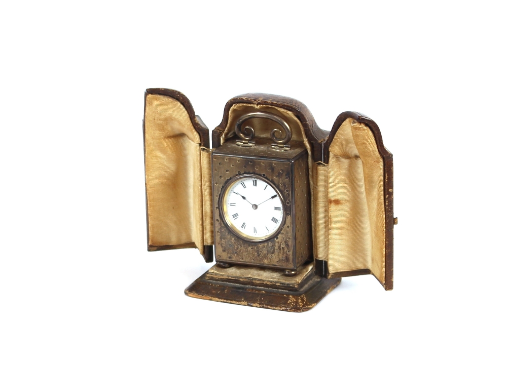 A miniature silver gilt carriage clock, contained in a leather folding travelling case