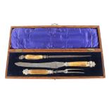 A Victorian oak cased three piece carving set, having horn handles and silver ferrules