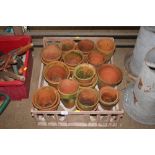 A plastic tray of various terracotta planters