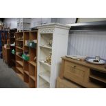 A white painted open fronted bookcase fitted two d